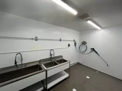 Stainless steel washroom with installed pipework, hose point and trigger gun connected to the wall-mounted pressure washer system in Nottingham